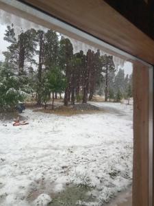 a view of a snow covered field from a window at Anacrusa Hostel in Epuyén