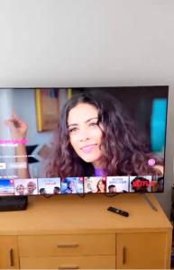 a television screen with a picture of a woman at BLESSED HOME in Bolton