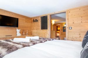 a bedroom with a large bed and a flat screen tv at Val Thorens - Cosy Duplex Pied des pistes Silveralp 003 in Val Thorens