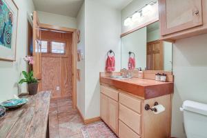un baño con lavabo y espejo en Lake Whitney Cabin with Hot Tub and Fire Pit!, en Morgan 25 fotos más