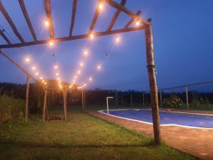 a string of lights over a swimming pool at night at Casa de Campo / Sítio + Chalé Suíço + Área Festa + Piscina in Tatuí +61 photos