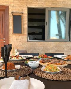 una mesa con muchos platos de comida. en Serenity Terraces Beach, Hotel - Kokrobite, en Kokrobite