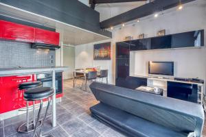 a kitchen with red cabinets and a bar with stools at Le Commandant - Paul Mistral - Stade des Alpes in Grenoble +3 photos