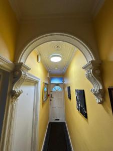 an archway leading to a hallway with a white door at Luton Town House Near AIRPORT in Luton