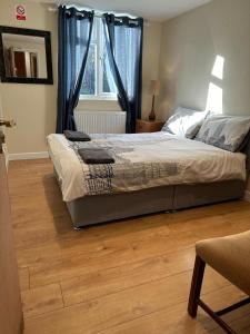 a bedroom with a bed and a wooden floor at Luton Town House Near AIRPORT in Luton