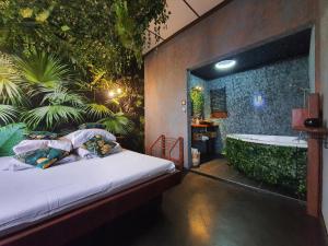 a bedroom with a bath tub and a bed with pillows at Tropicana Jacuzzi Apartment in Kraków