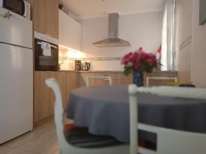 a kitchen with a table with a vase of flowers at Apartament MaxMax in Los Abrigos +36 photos