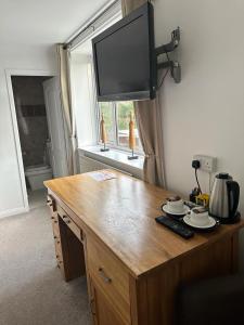 a wooden table with a television on top of it at The Swan Inn Salisbury in Wilton