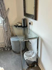 a glass desk with a chair and a mirror at The Swan Inn Salisbury in Wilton