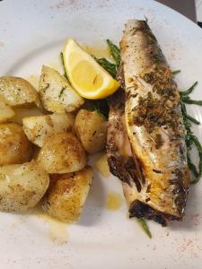 a plate of food with a piece of fish and potatoes at The Swan Inn Salisbury in Wilton