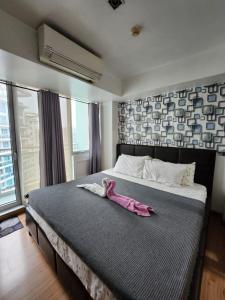 a bedroom with a bed with a pink animal on it at Azure Urban Resort in Manila