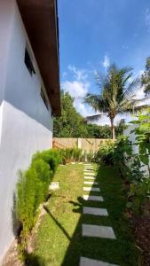 een pad dat leidt naar een tuin met een palmboom bij Sinta at Irog Private Villas in Bancal