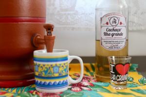een kopje koffie en een fles alcohol bij Casa Matatiso - quartos privados em casa compartilhada in Abraão