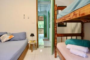 a bedroom with a bunk bed and a couch at Casa Matatiso - quartos privados em casa compartilhada in Abraão