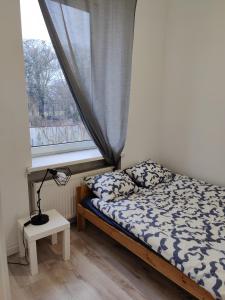 a small bedroom with a bed and a window at Konopnickiej 9 Apartament Loft dostęp na kod in Pabianice
