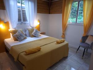 una camera da letto con un letto con due orsacchiotti sopra di Cottages Les Ventilés a Deshaies Altre 12 foto