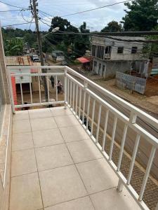 een balkon van een huis met een witte leuning bij Guesthouse Celeste in São Tomé +8 foto's