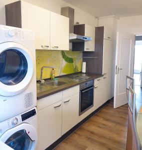 uma cozinha branca com máquina de lavar e secar roupa em J&L Apartment Industrie Nord em Friburgo em Brisgóvia