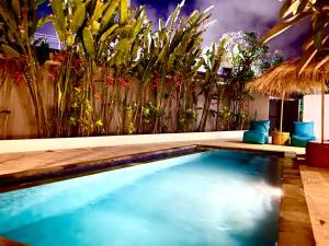 a swimming pool in a room with plants at Hotel Summer Of Surf in Ungasan