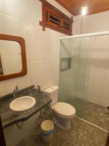 a bathroom with a toilet and a sink and a mirror at Maceió Kite House in Camocim