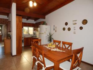 a kitchen and dining room with a wooden table and chairs at De la plaza in Concordia
