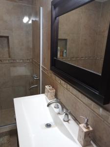 une salle de bains avec un lavabo blanc et un miroir dans l'établissement De la plaza, à Concordia 5 autres photos