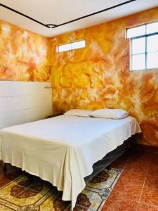 ein Schlafzimmer mit einem weißen Bett in einem Zimmer in der Unterkunft Mi casa es tu casa in San Pedro La Laguna