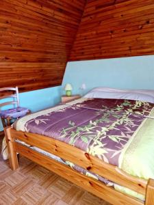 ein Bett in einem Zimmer mit Holzdecke in der Unterkunft Le Casimir, Maison de campagne à Estaing in Le Nayrac