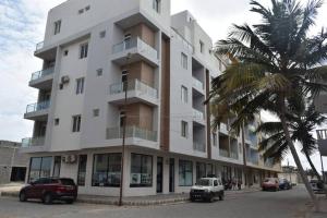 a tall white building with a palm tree in front of it at Casa Mirka App 15 in Sal Rei