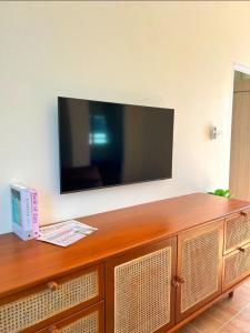 Elle comprend une télévision à écran plat installée au-dessus d'un meuble en bois. dans l'établissement The guesthouse, à Ban Nong Bua (1)
