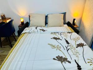 um quarto com uma cama com um cobertor em Studio Cosy proche Paris - JO 2024 em Clichy