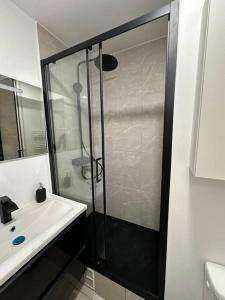 uma casa de banho com um chuveiro e um lavatório branco em Studio Cosy proche Paris - JO 2024 em Clichy