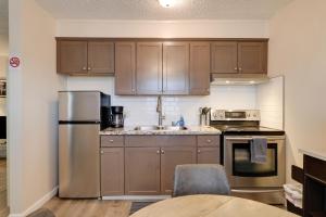 a kitchen with wooden cabinets and stainless steel appliances at Fresno Apartment with Shared Grill and Dining Area in Fresno