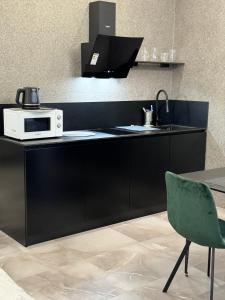 una cucina con bancone, forno a microonde e sedia di Apartment Delmar Lux ЦЕНТР a Dnipro