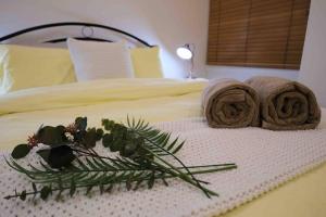 een bed met twee handdoeken en planten erop bij Comfortable City Apartment *Wi-Fi* in Melbourne