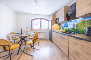 a kitchen with a table and chairs in a room at U Majerczyka Dolina Apartment in Zakopane