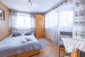 a small bedroom with a bed and a table at U Majerczyka Dolina Apartment in Zakopane