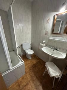 a bathroom with a sink and a toilet and a tub at Hostal agripino y Restaurante asiático in Mora