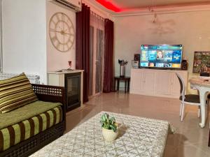 sala de estar con sofá y TV en Confortables location familiale vue sur mer à Sidj Fredj, en Staoueli
