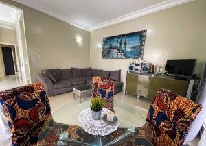 sala de estar con sofá, mesa y sillas en Lav's Place en Brufut