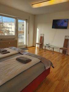 um quarto com uma cama grande e uma janela grande em J&L Apartment Industrie Nord em Friburgo em Brisgóvia