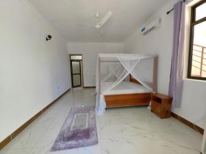 Habitación vacía con cama y ventana en Blue Tides Hotel en Nungwi