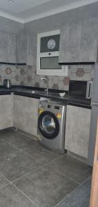 a kitchen with a washing machine and a microwave at شقق فندقيه مفروشه الترا مودرن للايجار in Cairo