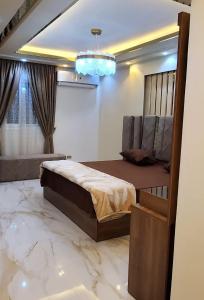 a bedroom with a bed and a marble floor at شقق فندقيه مفروشه الترا مودرن للايجار in Cairo