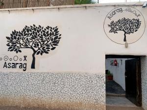 a white building with trees on the side of it at ASARAG in Mirleft