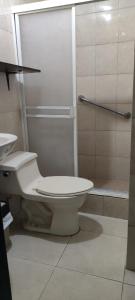 a white bathroom with a toilet and a shower at Hotel Mykonos Manta in Manta