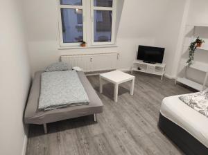 Habitación pequeña con 2 camas y TV. en Furnished apartments for employees with separate rooms, en Zeitz