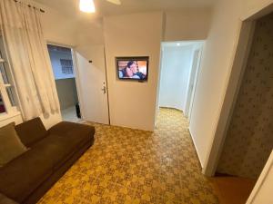 Una sala de estar con un sofá y un cuadro en la pared. en Pé na Areia Praia da Guilhermina, en Praia Grande