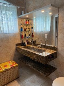 uma casa de banho com um grande lavatório e um espelho em Paraíso do santinho em Florianópolis