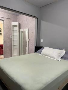 um quarto com uma cama grande e um espelho em Paraíso do santinho em Florianópolis